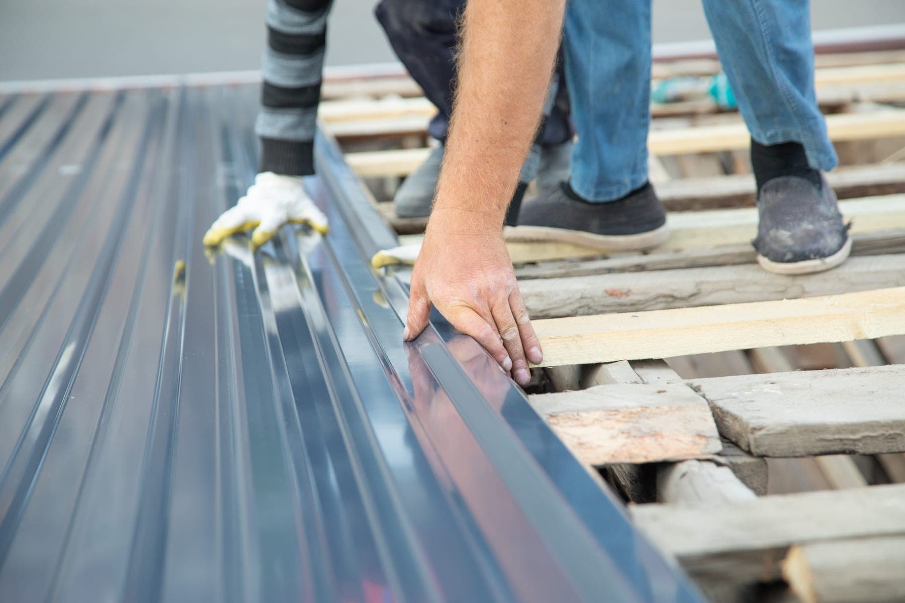 New metal sheeting being laid over timber battens